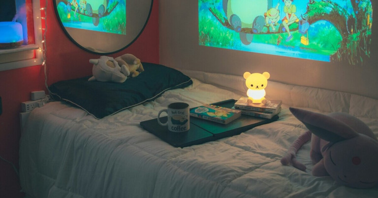 Gemütliches Schlafzimmer mit Nachtlicht und Kuscheltieren Gemütliches Schlafzimmer mit Bären-Nachtlicht, Kuscheltieren und Projektion an der Wand