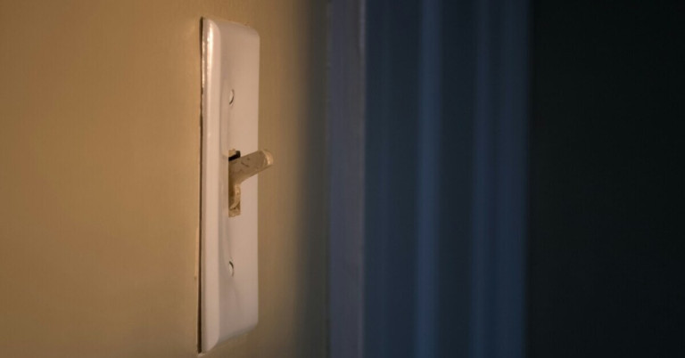 Lichtschalter – Nahaufnahme eines klassischen Lichtschalters an der Wand Lichtschalter an einer Wand in Nahaufnahme