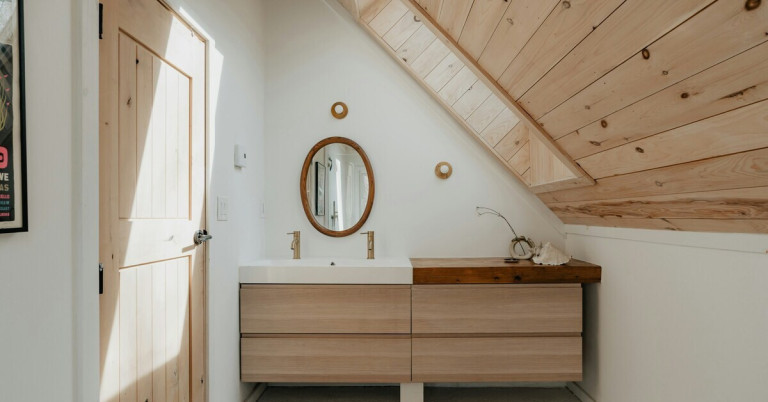 Modernes Badezimmer mit hellen Holzakzenten und minimalistischem Design unter Dachschräge