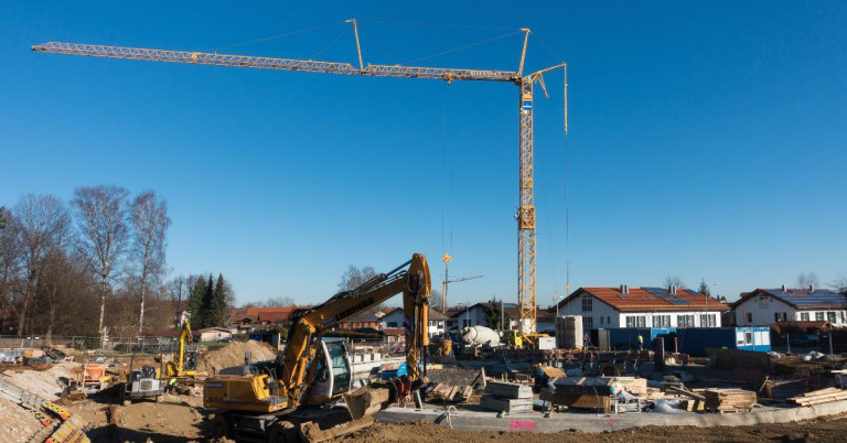 Baustelle Neubau mit Kran und Bagger Baustelle eines Neubaus mit Kran und Bagger bei sonnigem Wetter