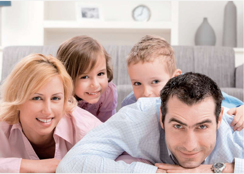 Glückliche Familie liegt zusammen im Wohnzimmer