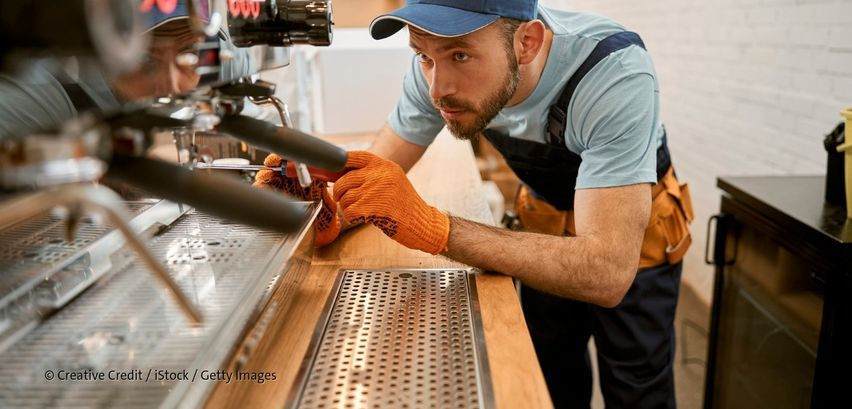 Handwerker bei der Arbeit an einer Kaffeemaschine