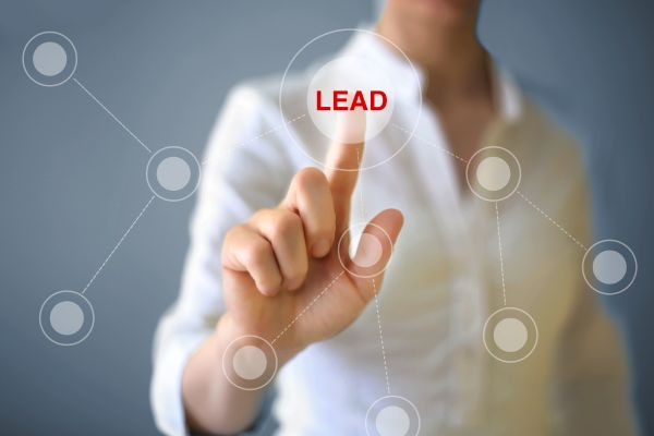 Conversionrate und Lead-Generierung visualisiert durch Fingerzeig auf 'Lead' Finger zeigt auf das Wort 'Lead' zur Verdeutlichung von Conversionrate und Lead-Generierung