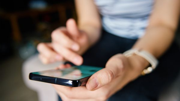 Person nutzt Smartphone für Social Media Werbung