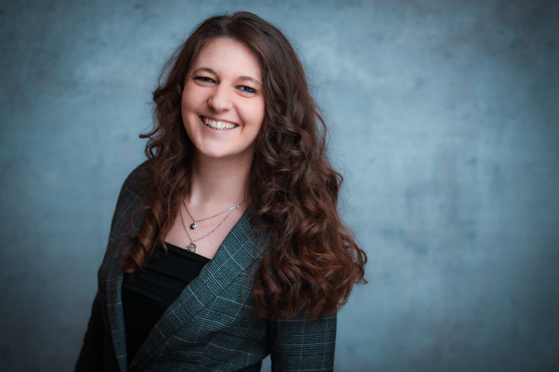 Lachendes Portrait von Maleen vor blauem Hintergrund