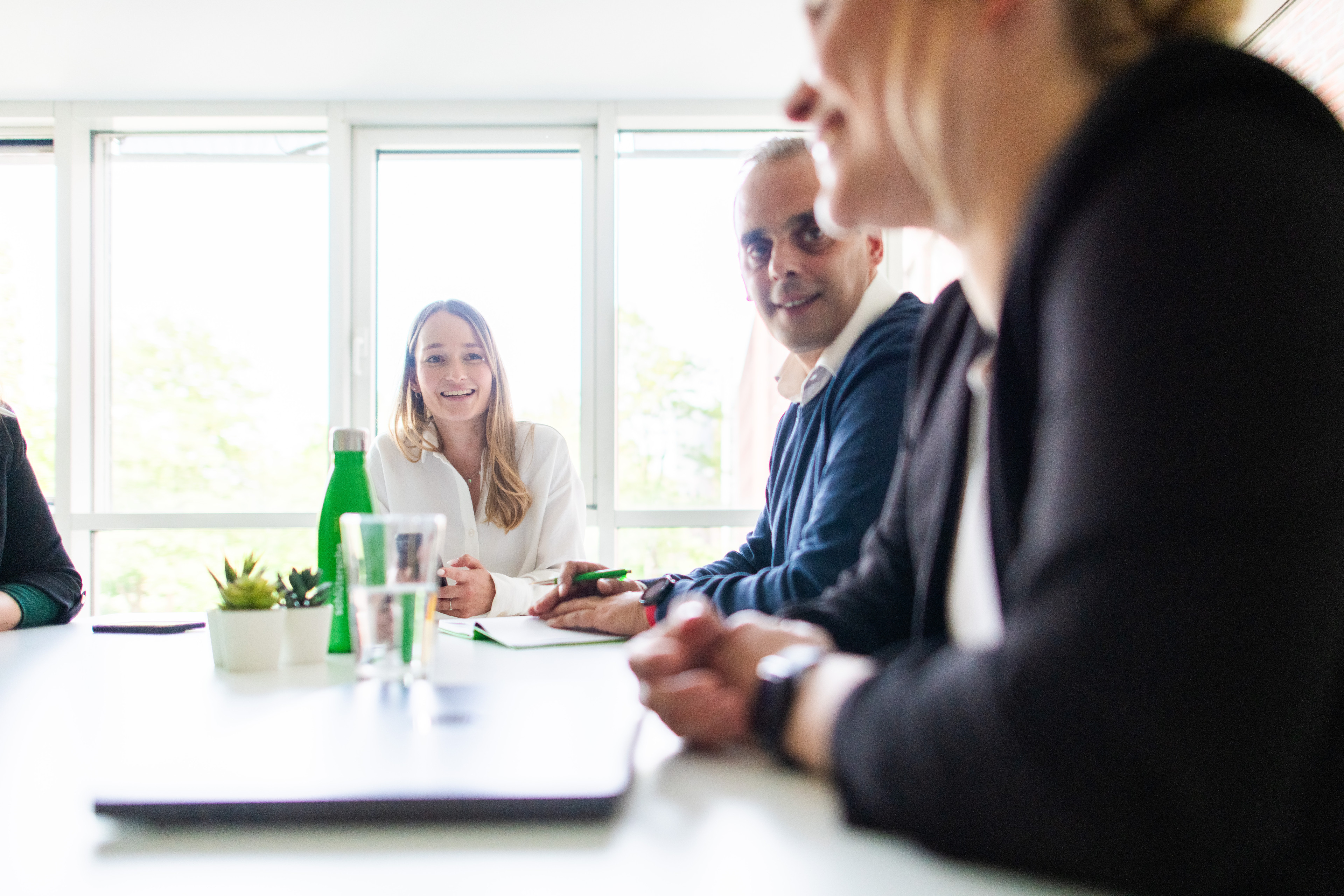 Teammeeting im Büro mit drei Personen am Tisch