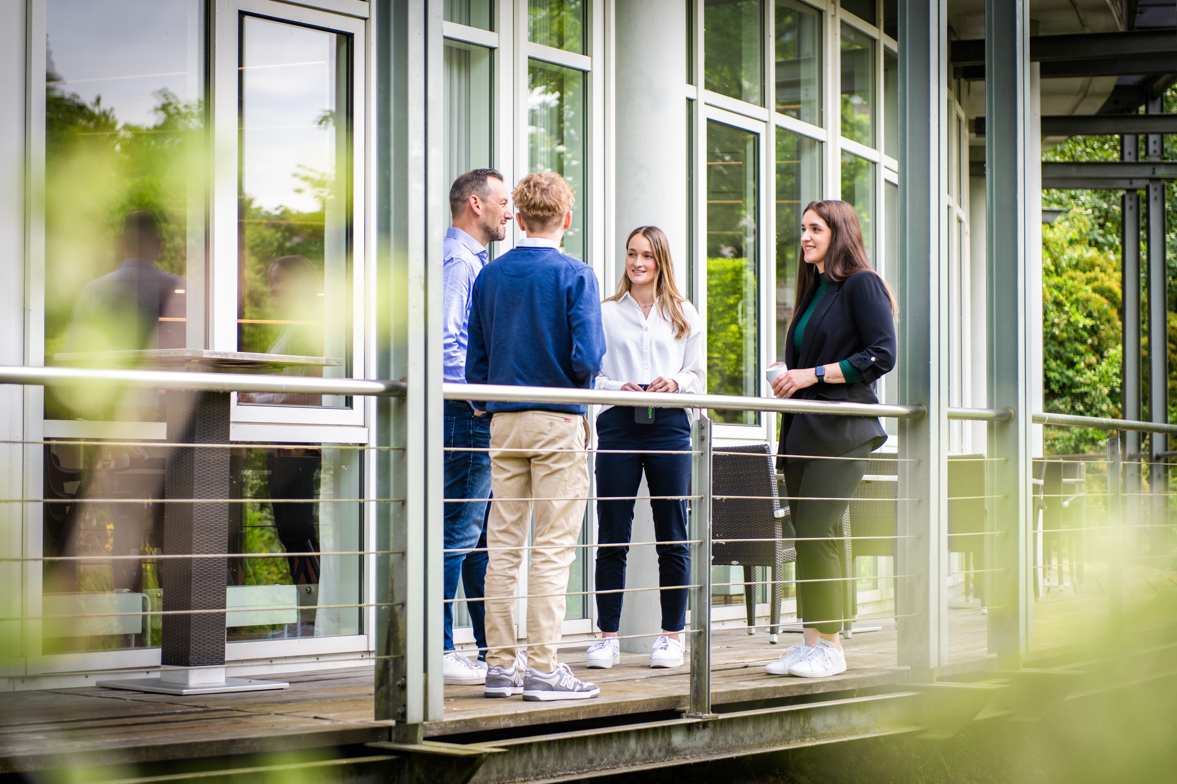 Teammeeting auf einem Balkon mit vier Personen