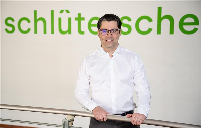 Marco Weiss vor einem Schild mit grünem Schriftzug