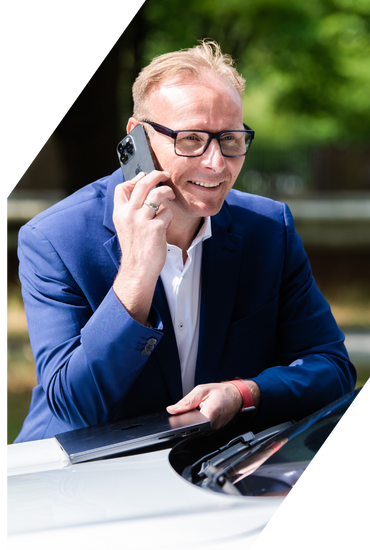 Person im Anzug telefoniert im Freien mit einem Smartphone