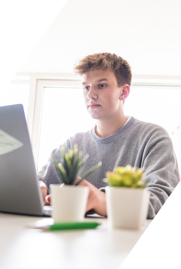 Student am Laptop erkundet Einstiegsmöglichkeiten in ein duales Studium