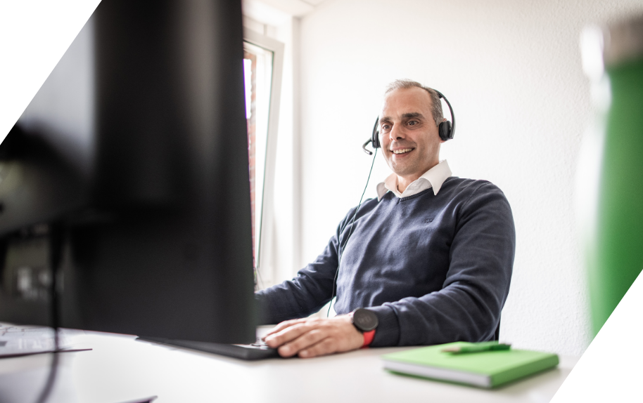 Mitarbeiter mit Headset bietet Kundenservice am Computer