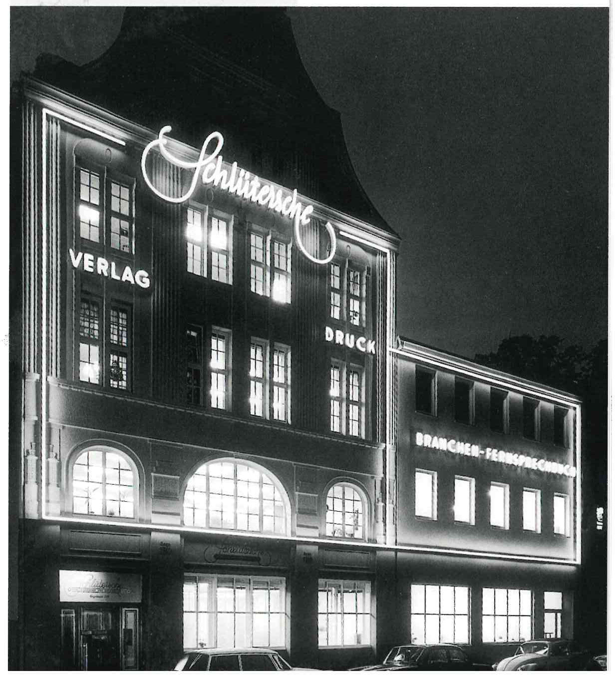 Historisches Verlagshaus der Schlüterschen bei Nacht mit beleuchtetem Schriftzug und Fassade