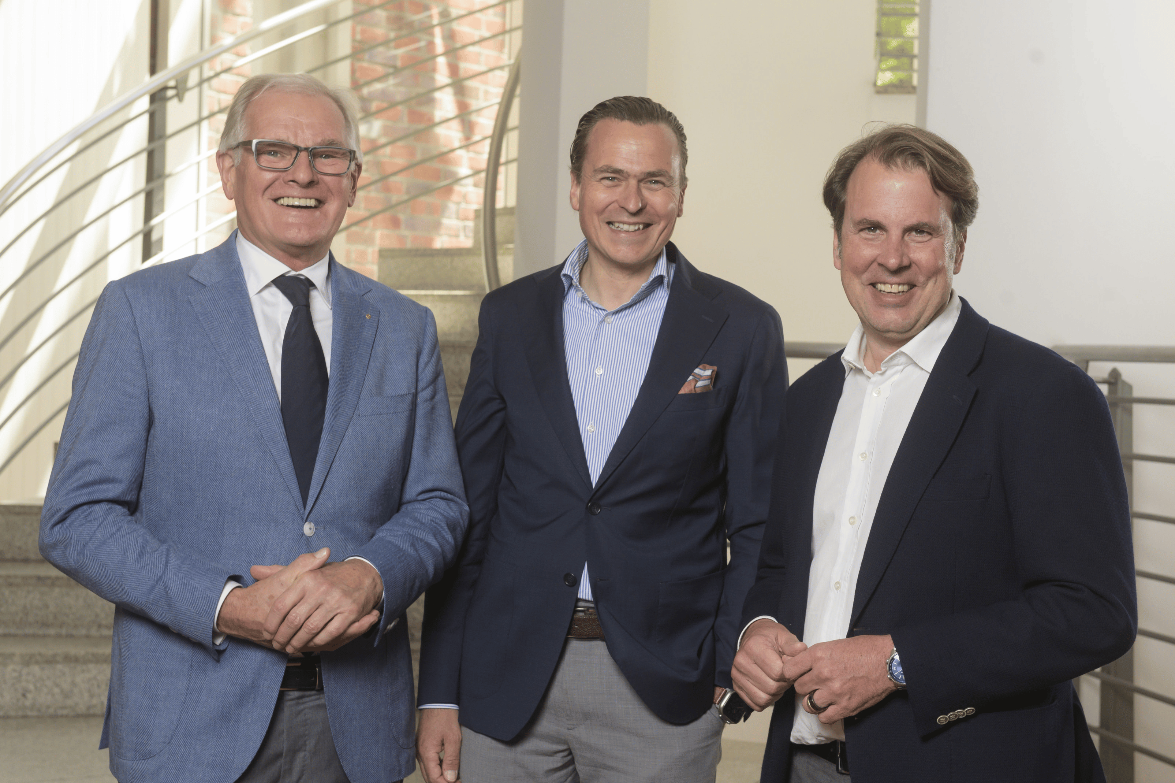 Mitglieder eines Beirats in Businesskleidung stehen gemeinsam vor einer Treppe