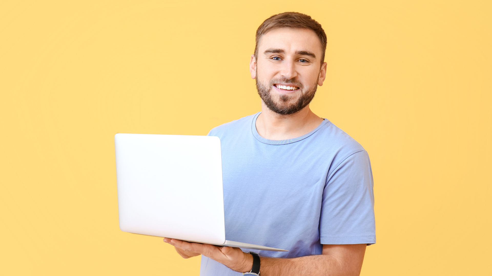 Mann mit Laptop vor gelbem Hintergrund zur Website-Relaunch