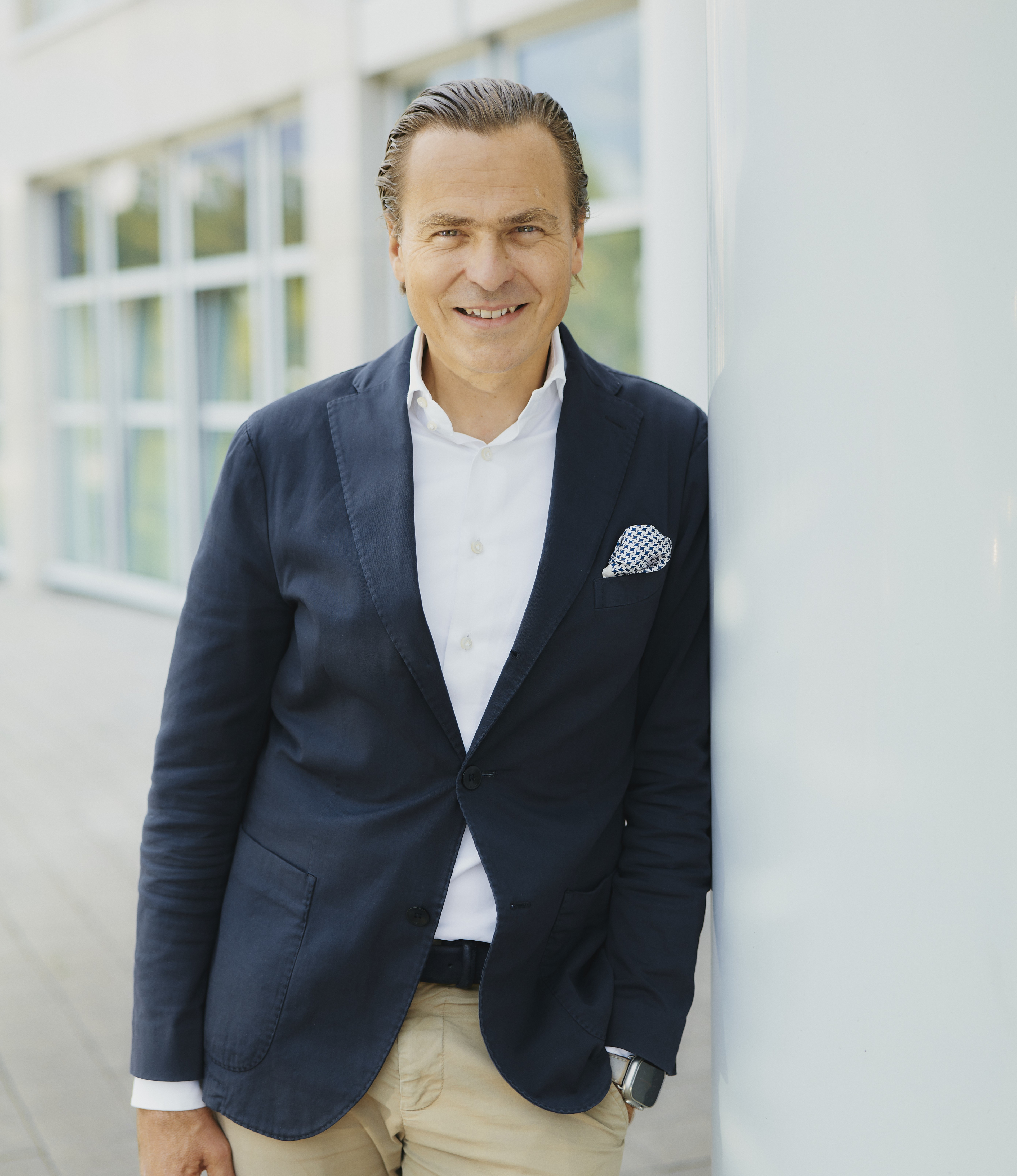 Business-Porträt im Anzug vor modernem Bürogebäude, Ausschnitt, heise, 23-08-23