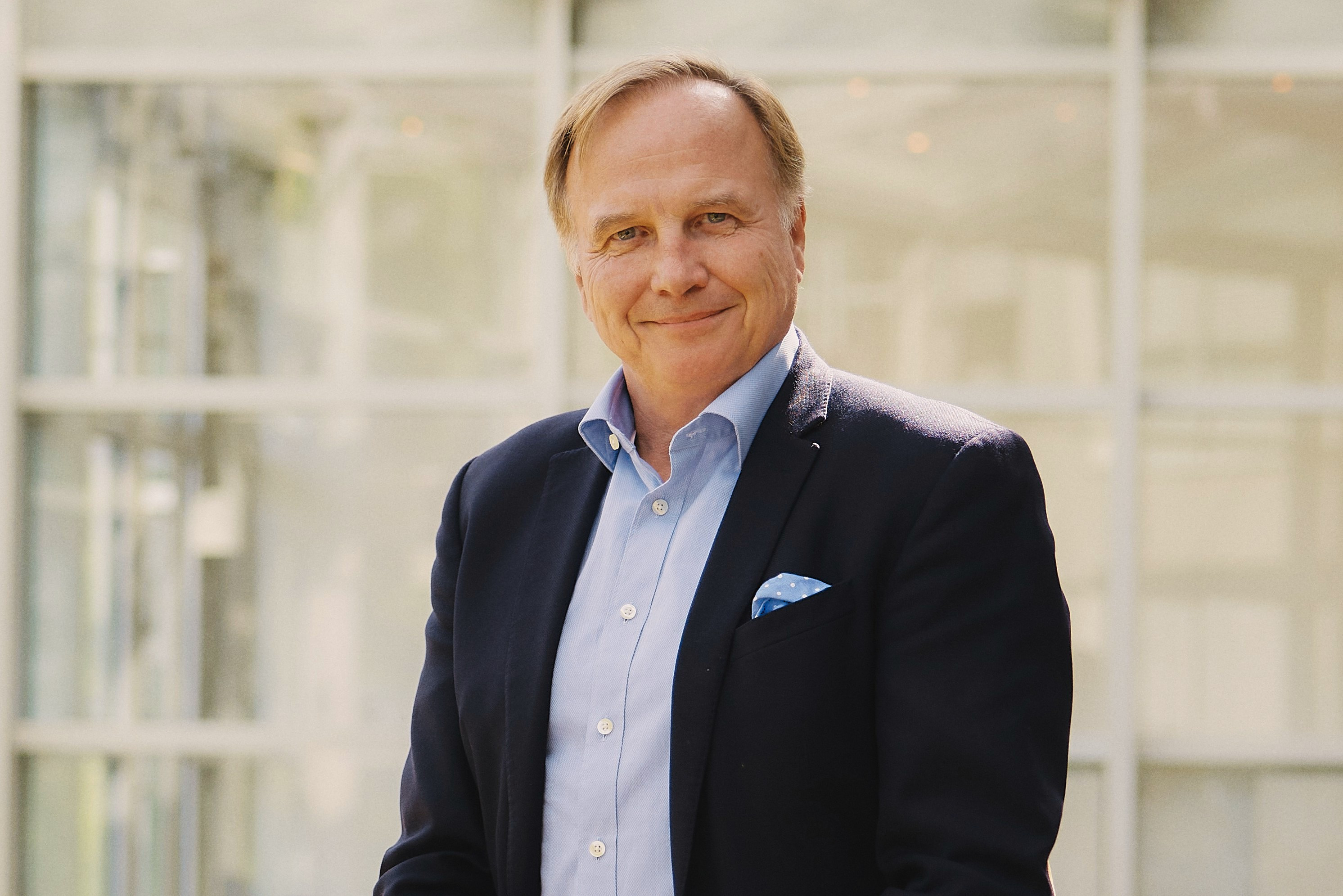 Oliver Till Dieckhaus im Anzug vor heller Glasfassade