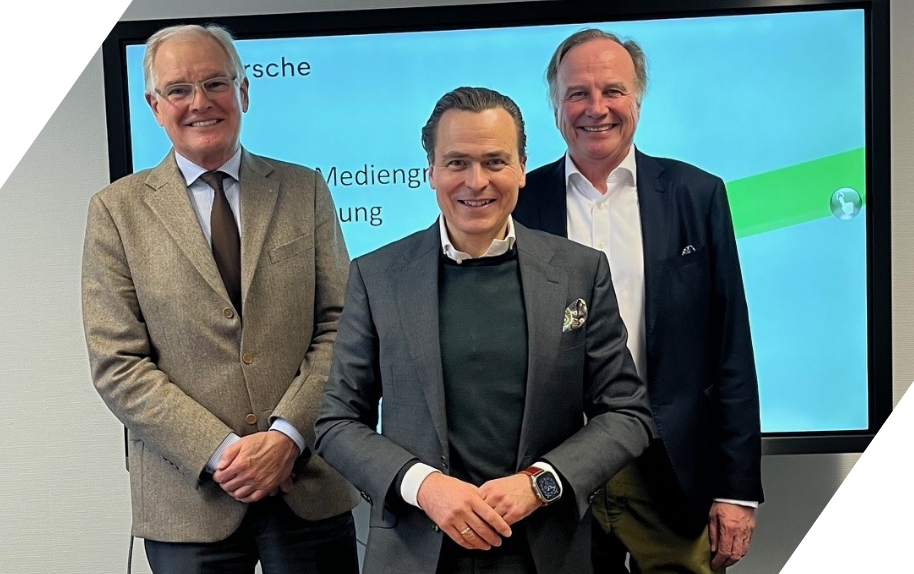 Geschäftsmänner im Anzug vor Präsentationsbildschirm bei einer Mediengruppensitzung