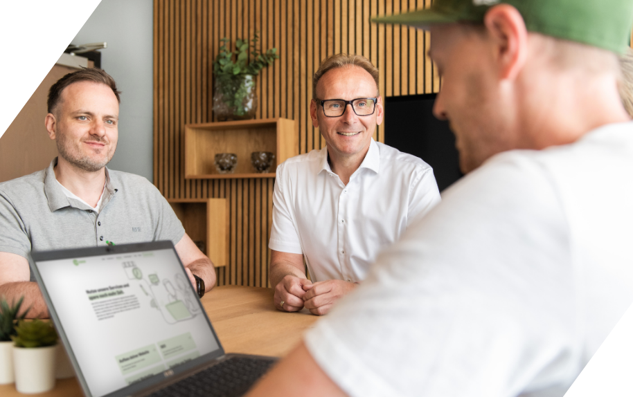 Benjamin Wahler im Meeting, Gespräch am Tisch mit Laptop, modernes Büro