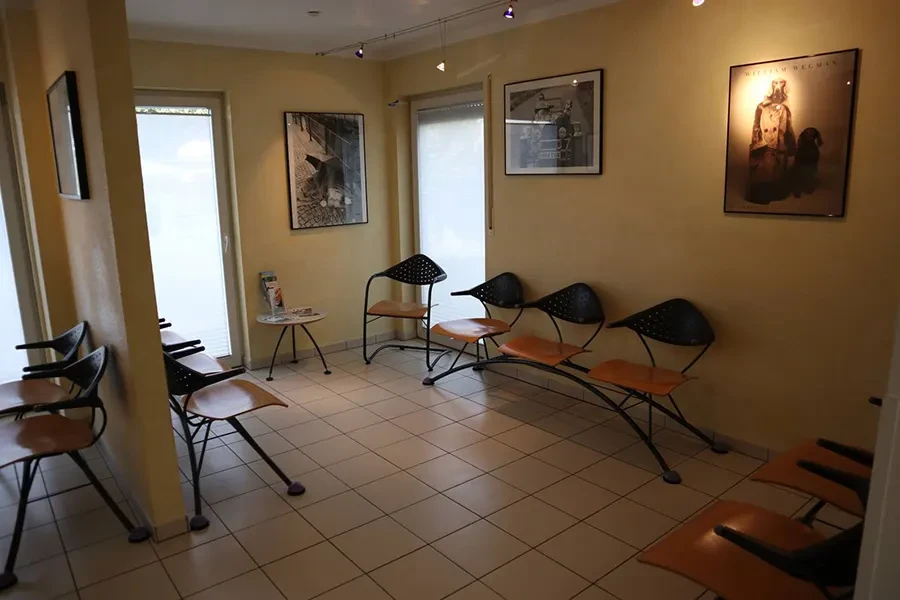 Warteraum einer Arztpraxis mit modernen Sitzmöglichkeiten und Wanddekoration Moderner Warteraum mit Sitzgelegenheiten und Wandbildern in einer Arztpraxis