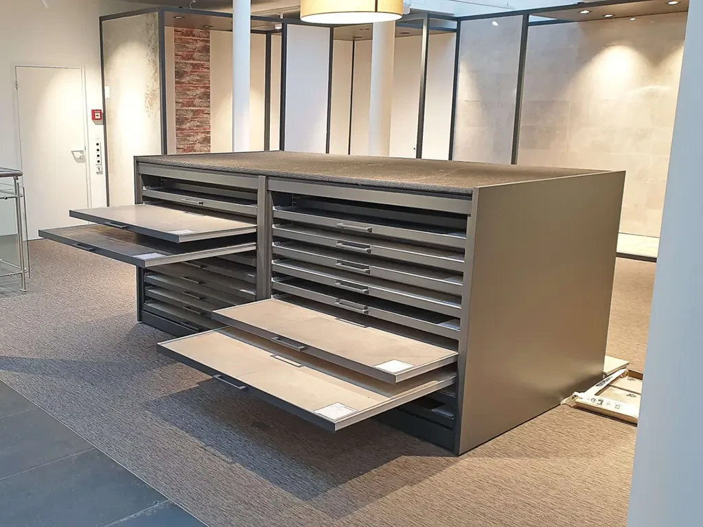 Moderner Musterschrank mit ausziehbaren Schubladen zur Präsentation von Materialmustern in einem Ausstellungsraum.