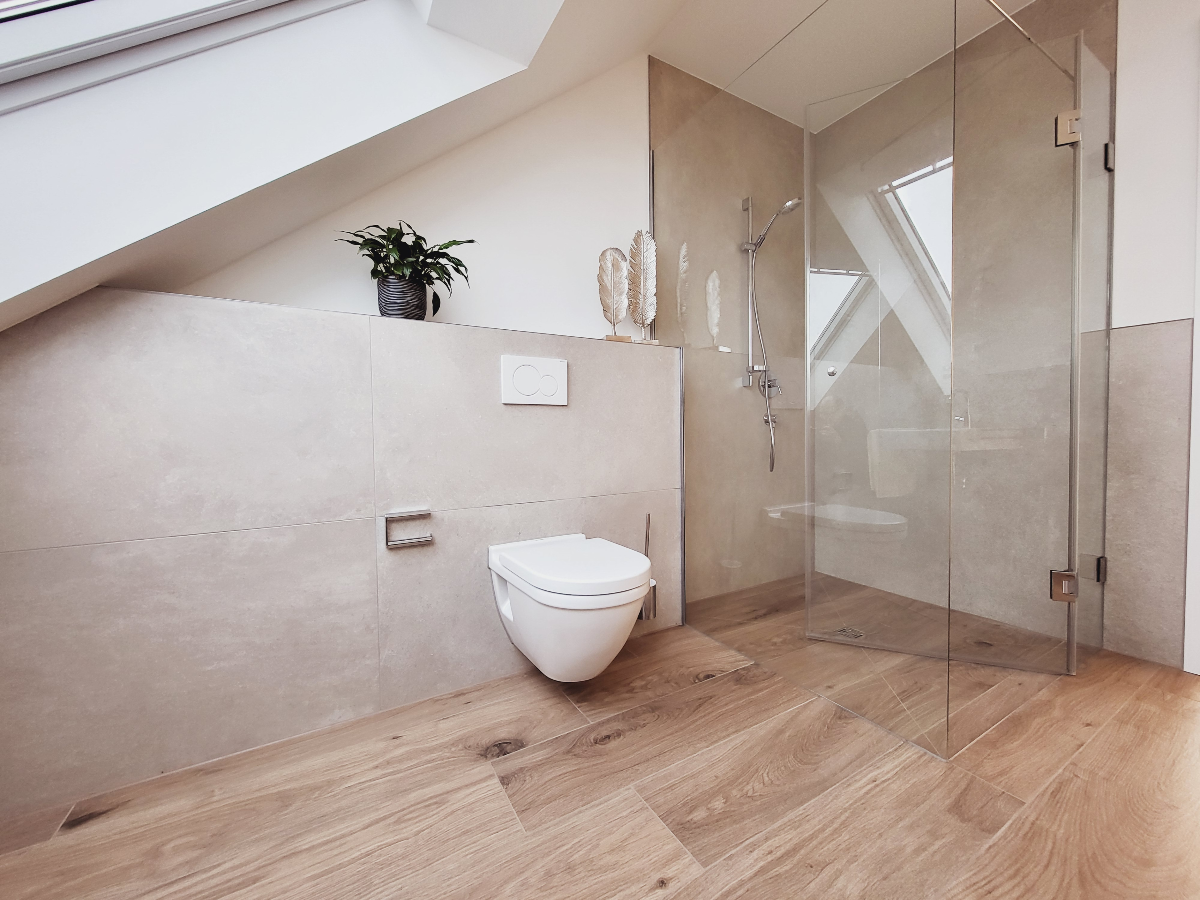 Modernes Badezimmer mit Hänge-WC, begehbarer Dusche und Holzoptik-Fliesen unter Dachschräge