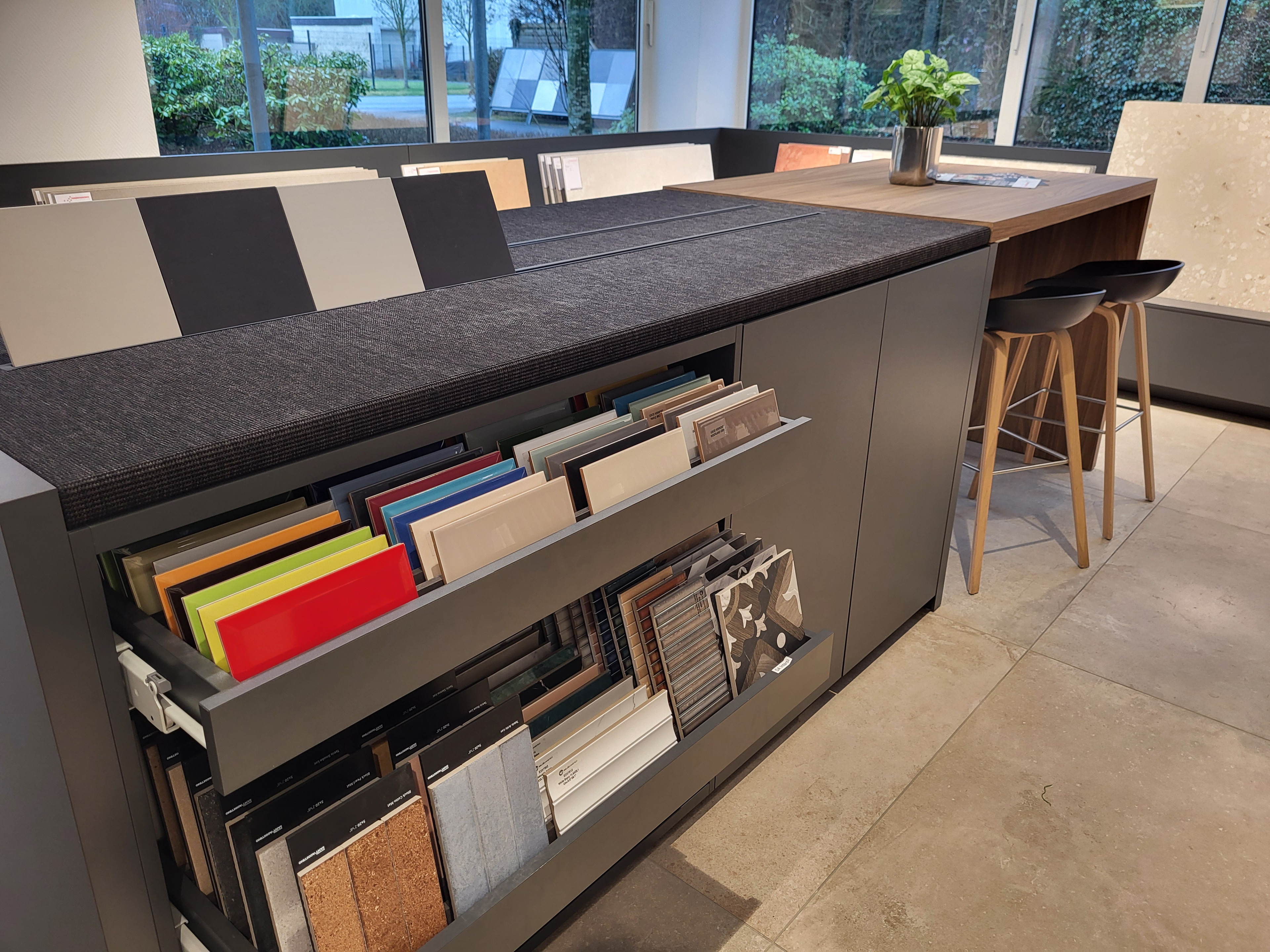 Foto einer Ausstellung mit verschiedenen Fliesen- und Materialmustern in einem modernen Showroom