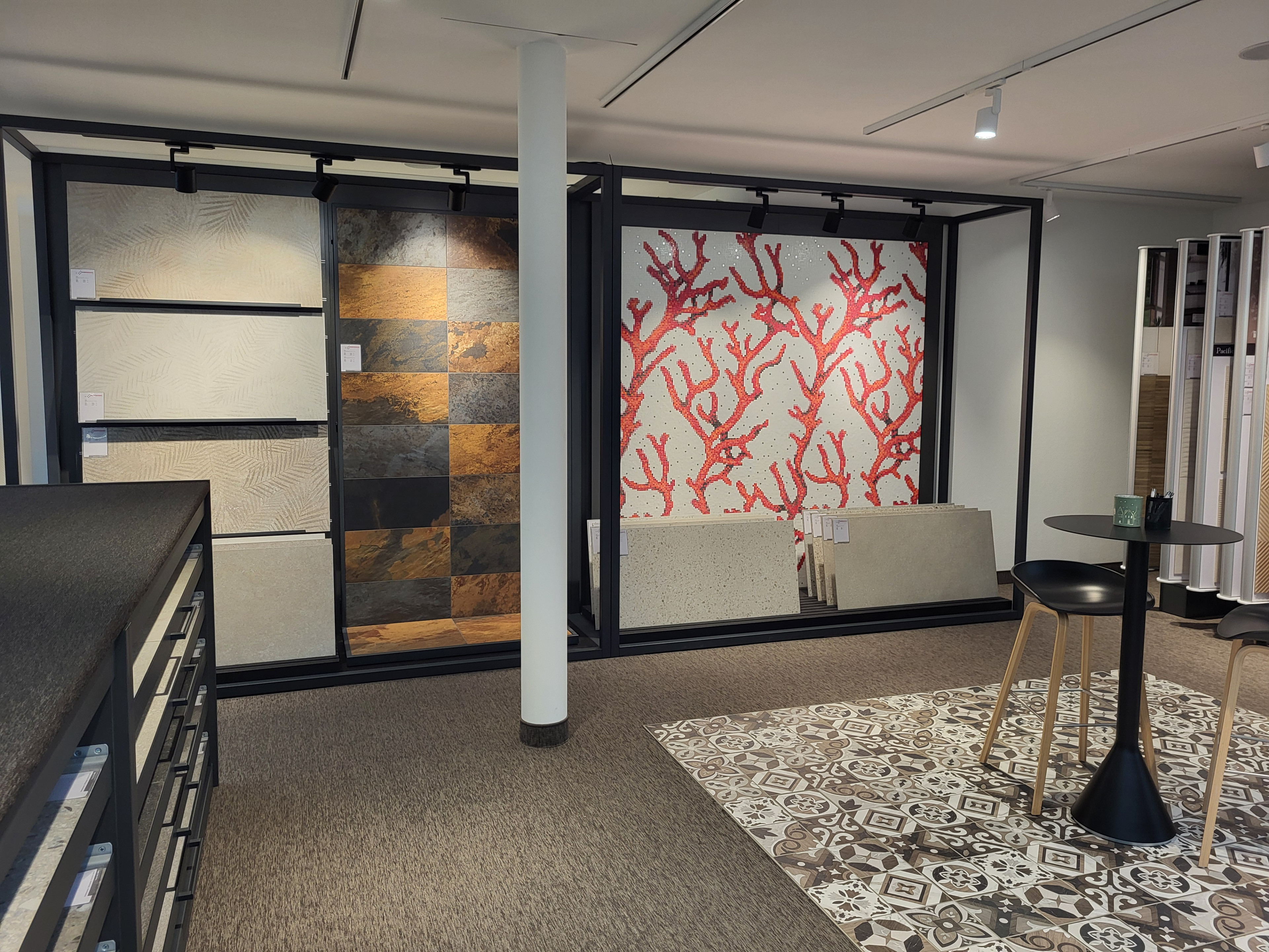 Ausstellung von Fliesen und Wandverkleidungen mit verschiedenen Mustern und Farben in einem Showroom