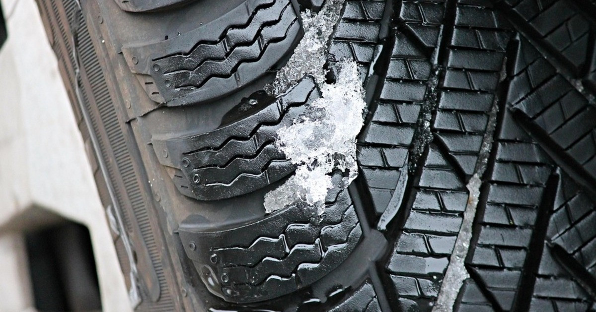 Detailaufnahme eines Winterreifens mit Schnee im Profil