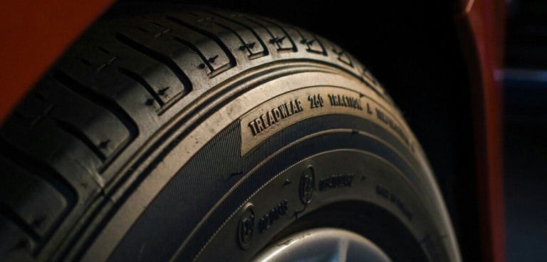 Nahaufnahme eines Autoreifens mit sichtbarer Lauffläche und Reifenbeschriftung