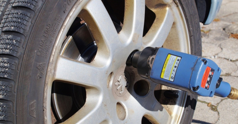 Schrauben festziehen an einer Autoreifenfelge mit einem Schlagschrauber