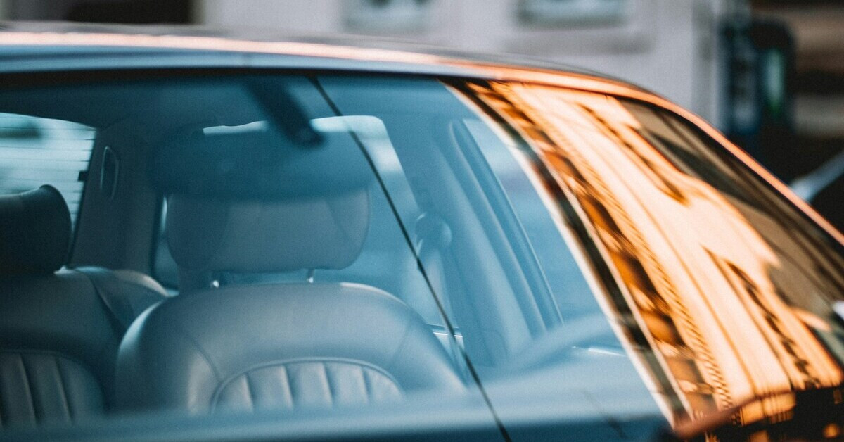 Autoscheibe mit Spiegelung und Fahrzeuginnenraum