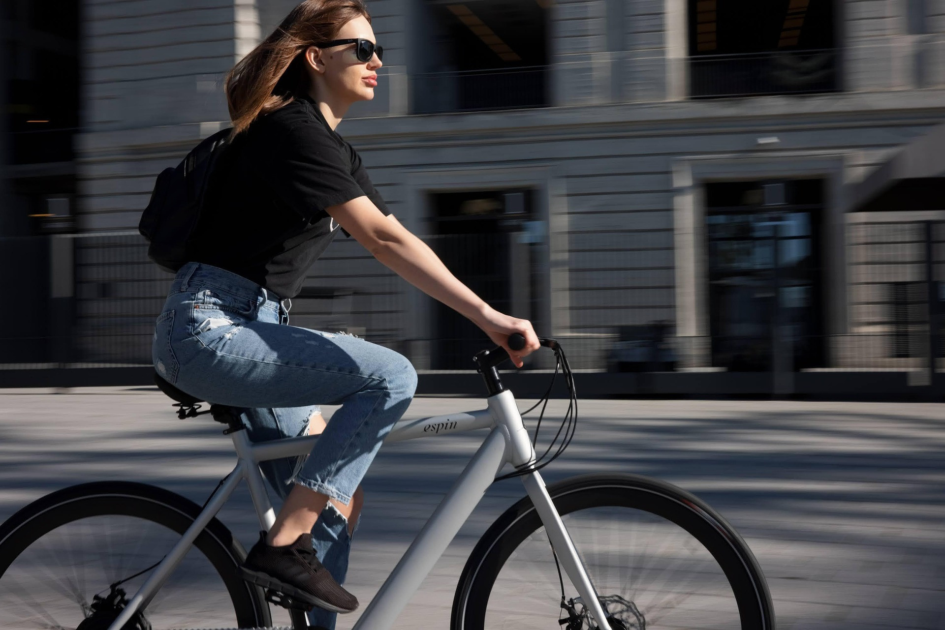 Frau fährt ein E-Bike durch die Stadt bei Tageslicht