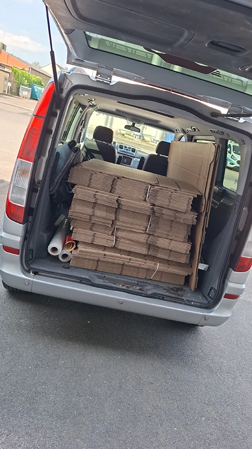 Offener Mercedes-Van mit Kartons im Laderaum
