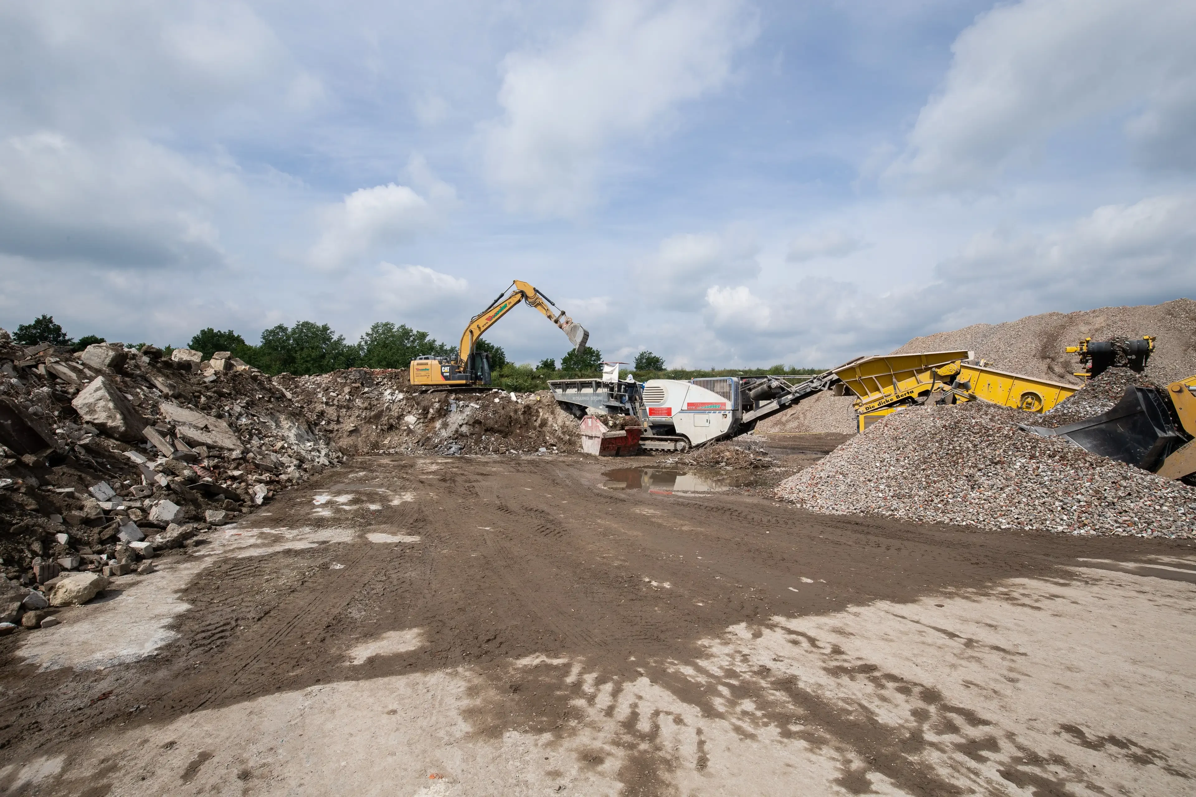 Bagger und Baumaschinen auf einer Baustelle beim Bewegen von Bauschutt
