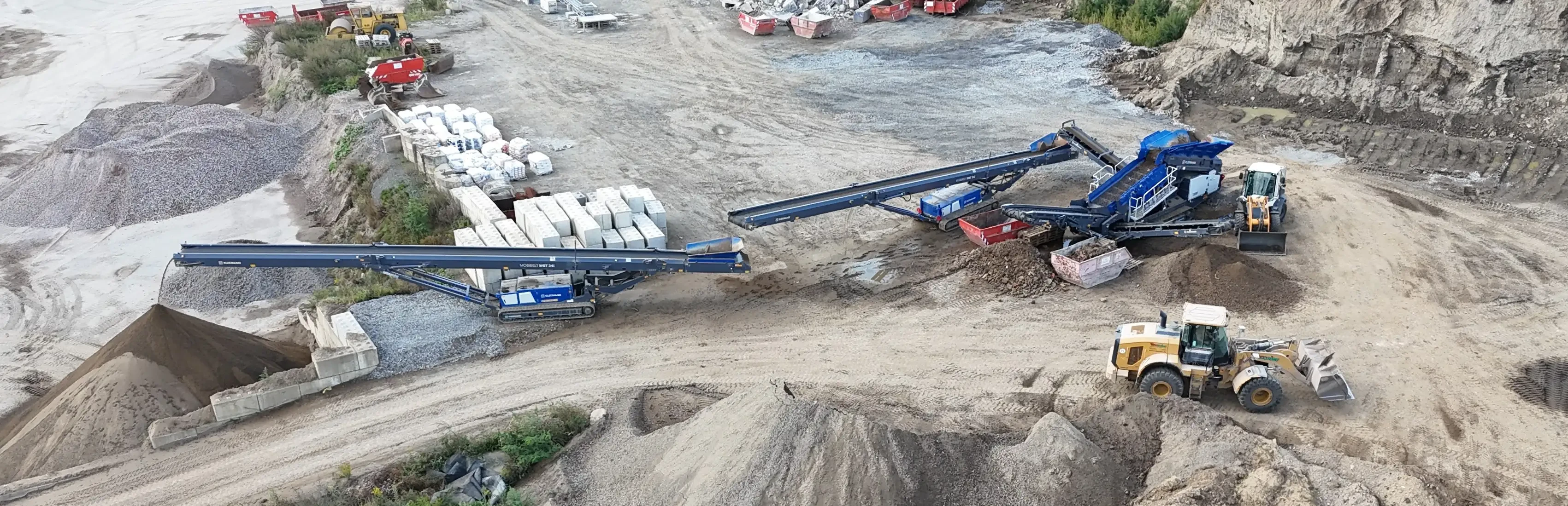 Baustelle mit Förderband und Baumaterialien, Luftaufnahme einer industriellen Anlage