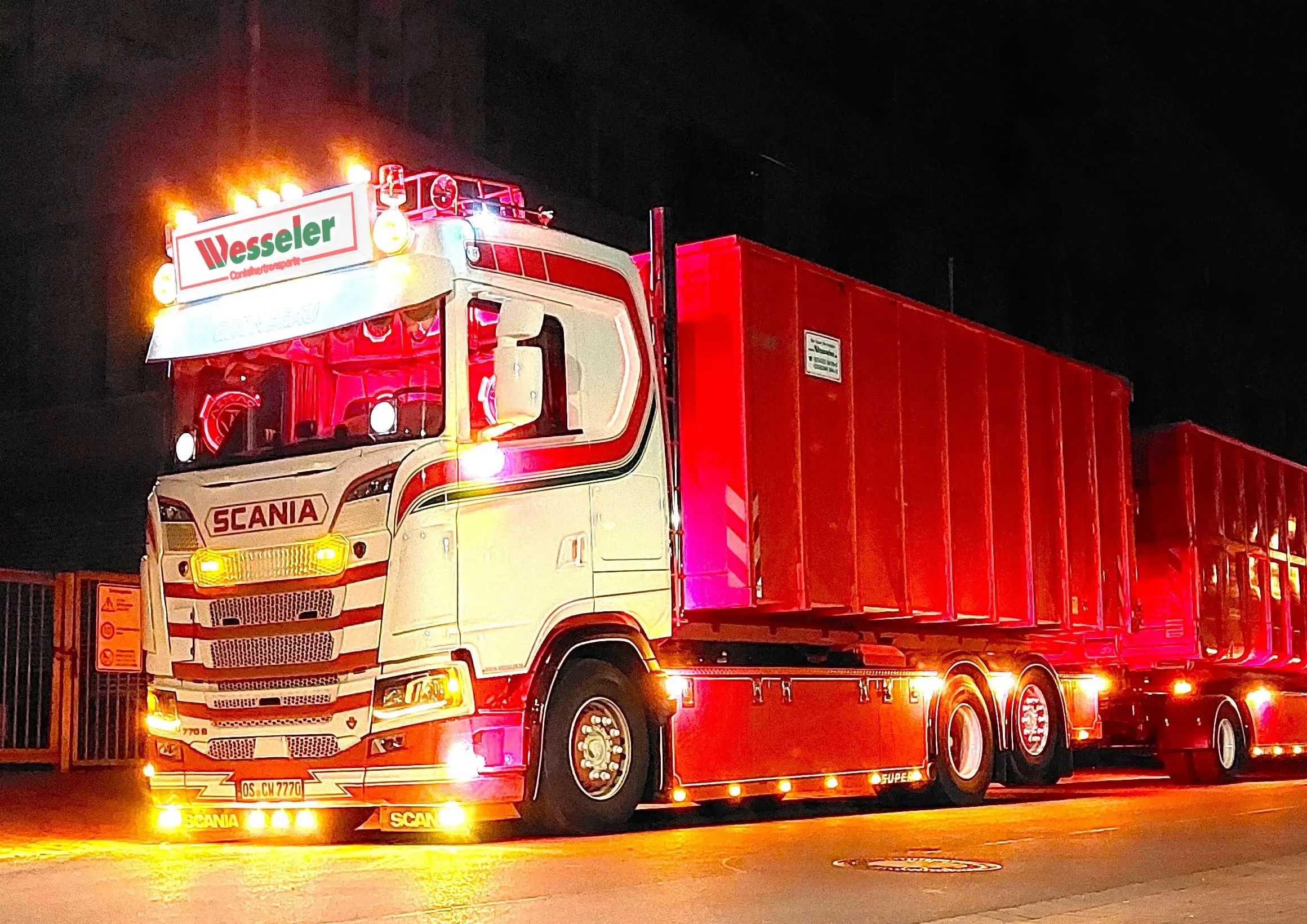 Moderner Arbeitsplatz: Beleuchteter LKW von Wesseler Containerdienst bei Nacht