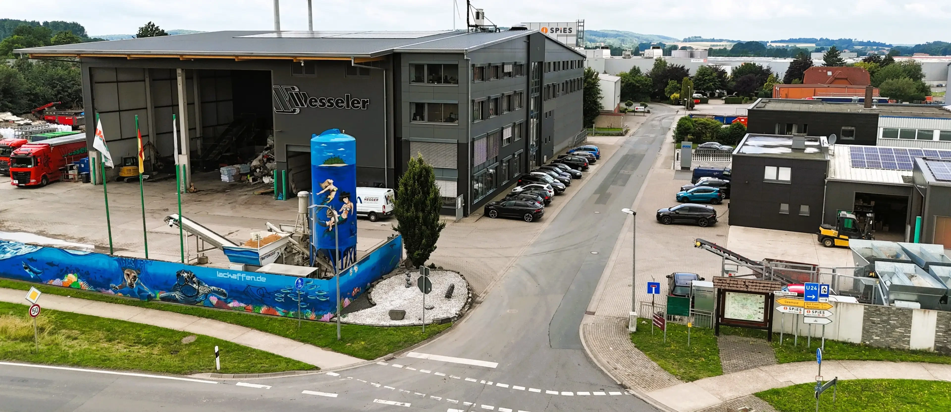 Industriegebäude in Gesmold mit bemaltem Silotank und Firmenparkplatz