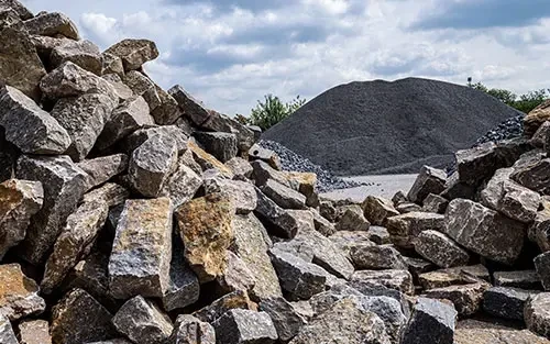 Natursteinhandel: Verschiedene Natursteine und Schotter auf einem Lagerplatz