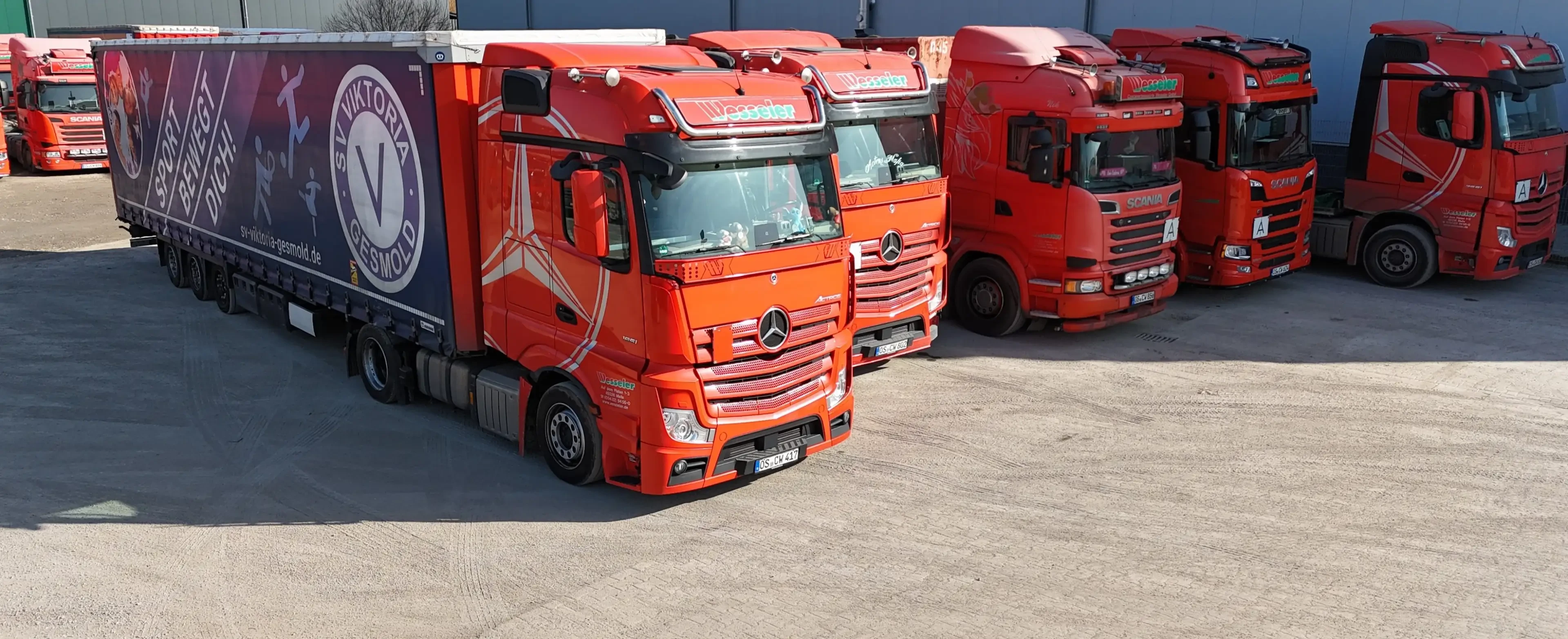 Rote Mercedes-Benz Lkw der Spedition Wesseler auf einem Parkplatz