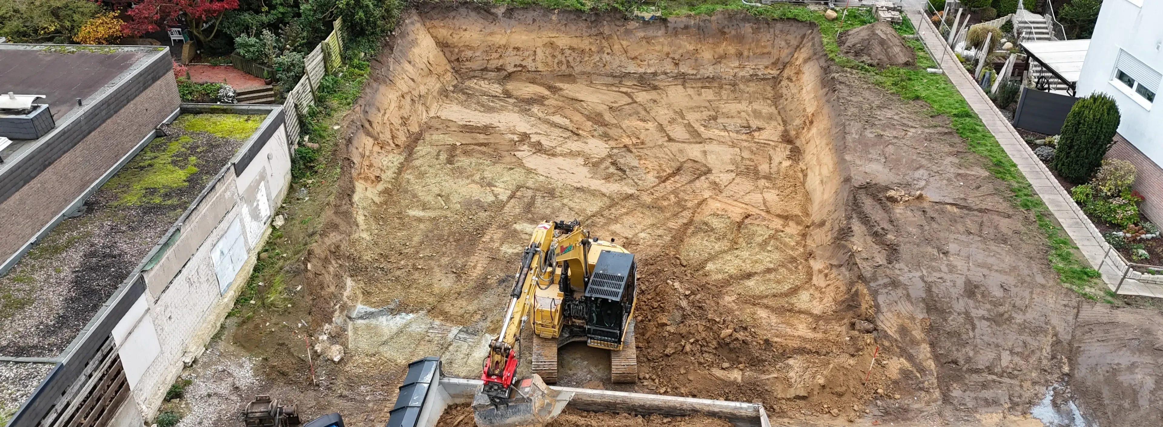 Bagger bei Erdarbeiten auf einer Baustelle, aus der Vogelperspektive aufgenommen