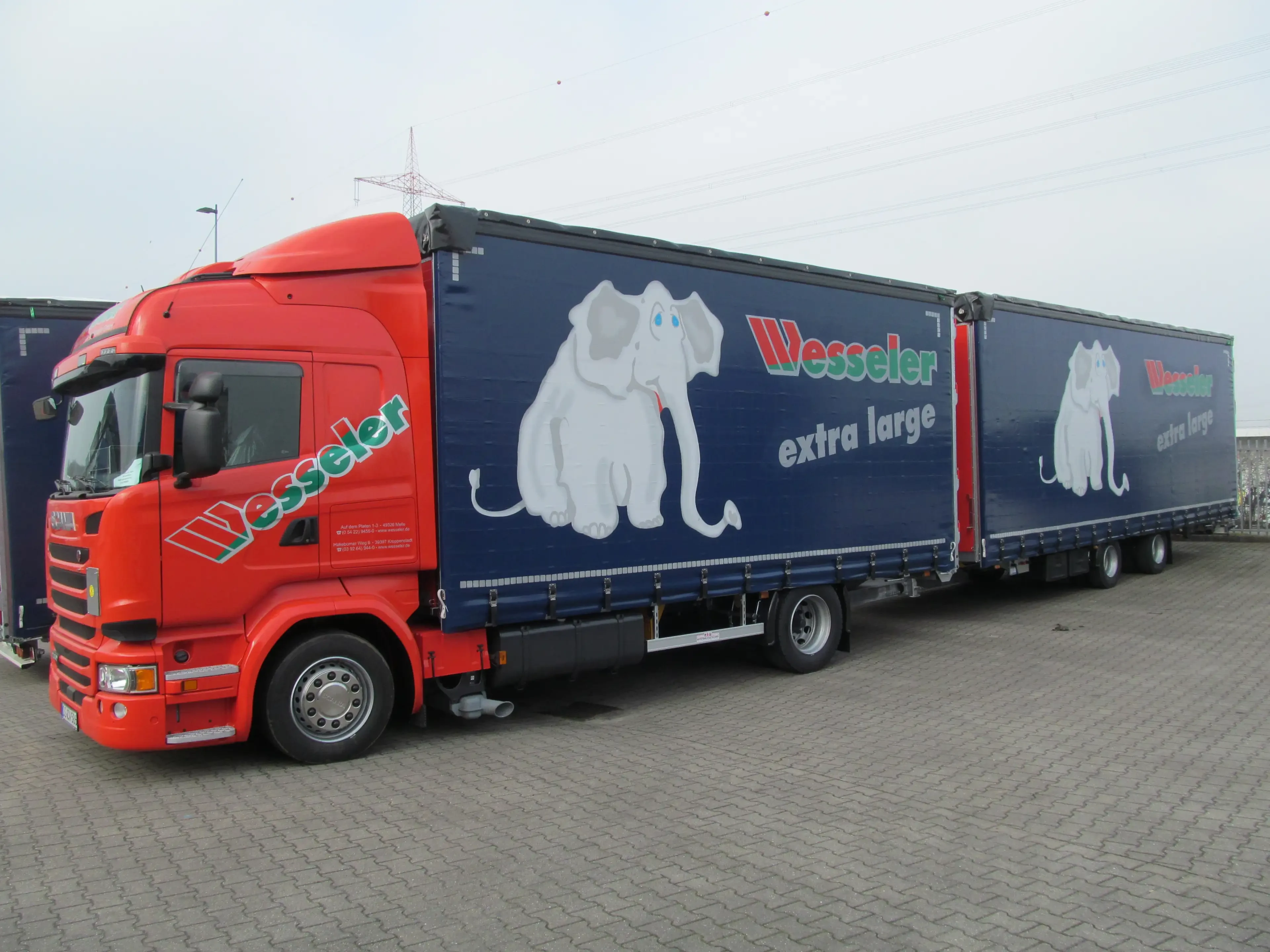 Wesseler LKW mit Elefanten-Motiv und Aufschrift 'extra large' auf dem Firmengelände