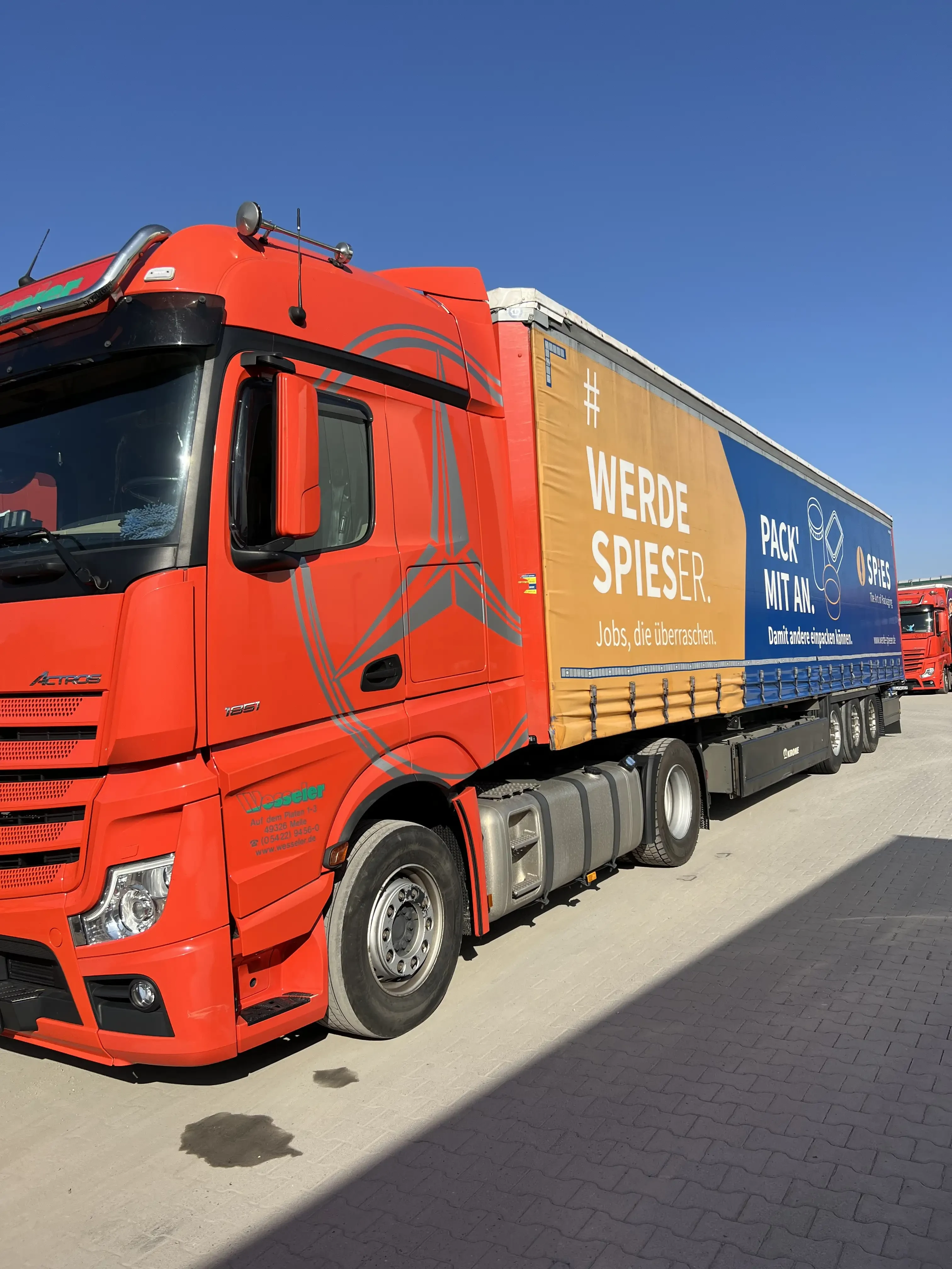 Roter LKW mit Spies Werbung und Slogan 'Werde Spieser. Jobs, die überraschen.' auf dem Parkplatz