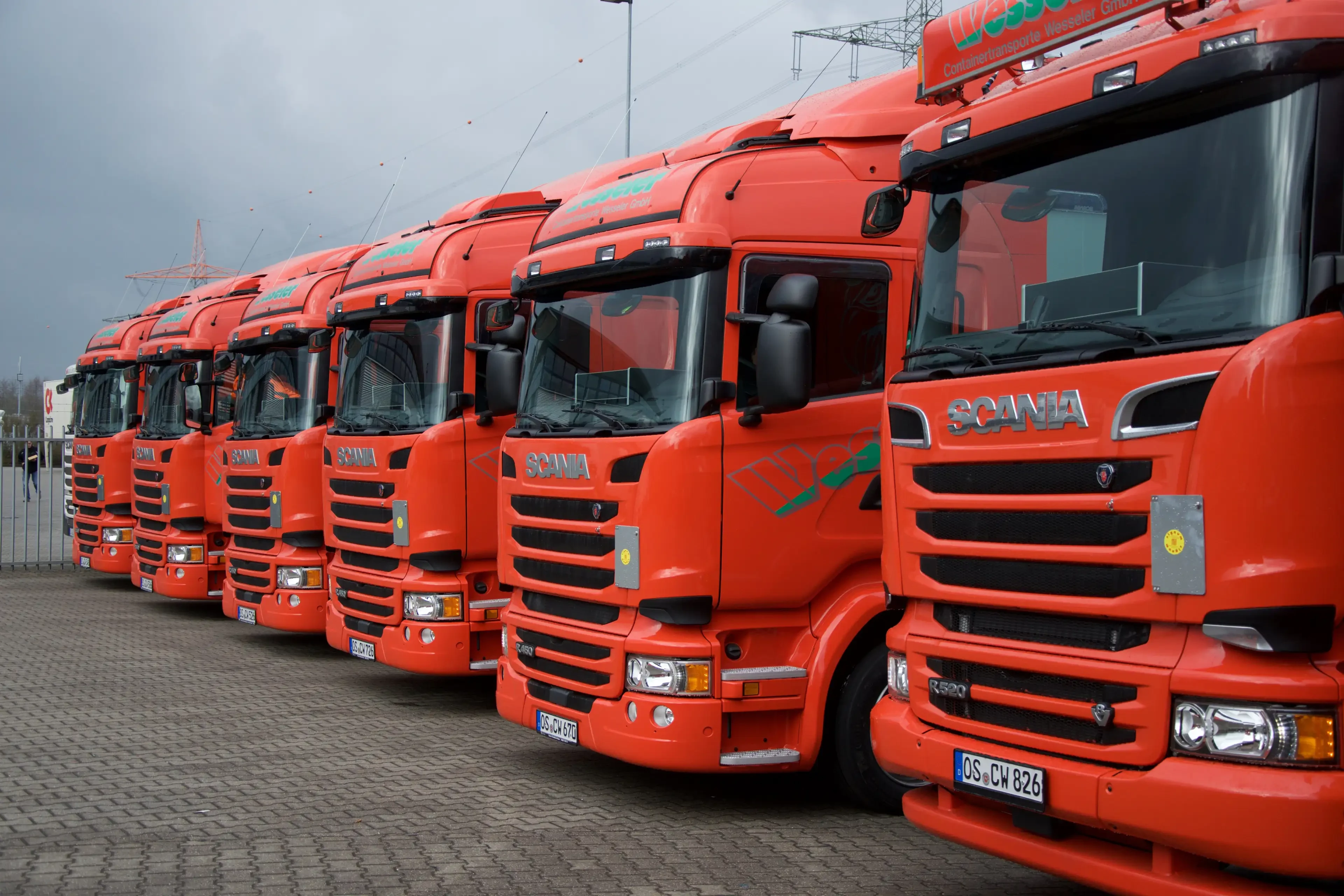 Reihe von roten Scania LKWs auf einem Parkplatz, Nahaufnahme der Fahrerkabinen