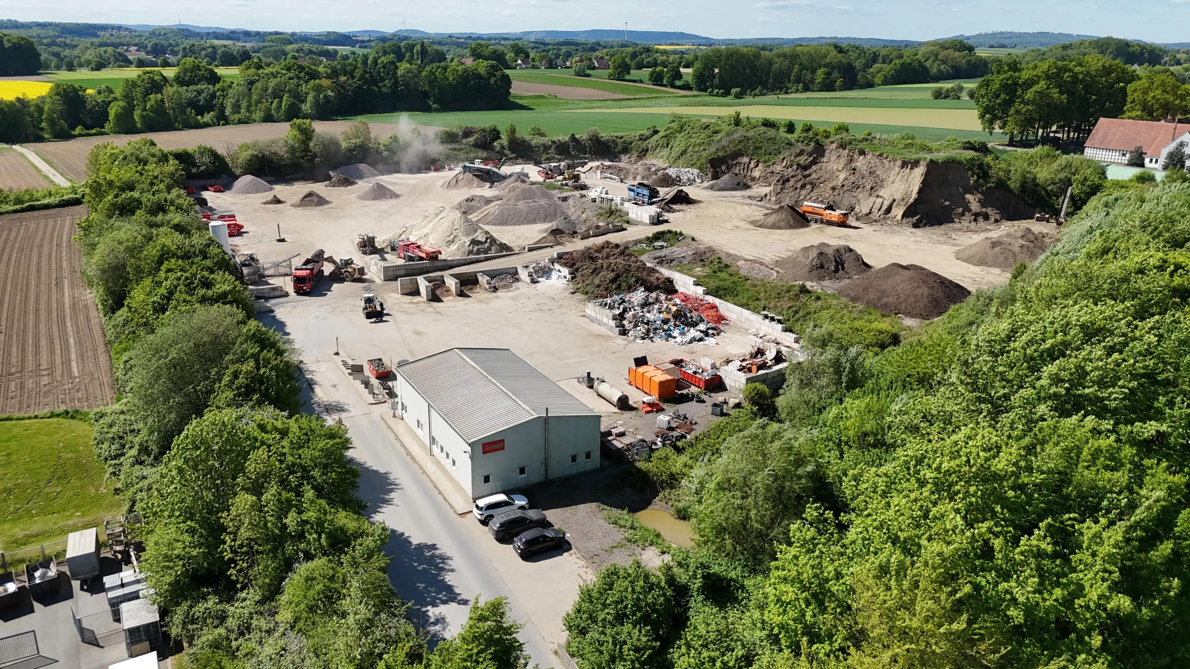 Luftaufnahme eines Recyclinghofs mit Lagerung von Baustoffen und Containern auf cxuc0794-jpg.webp