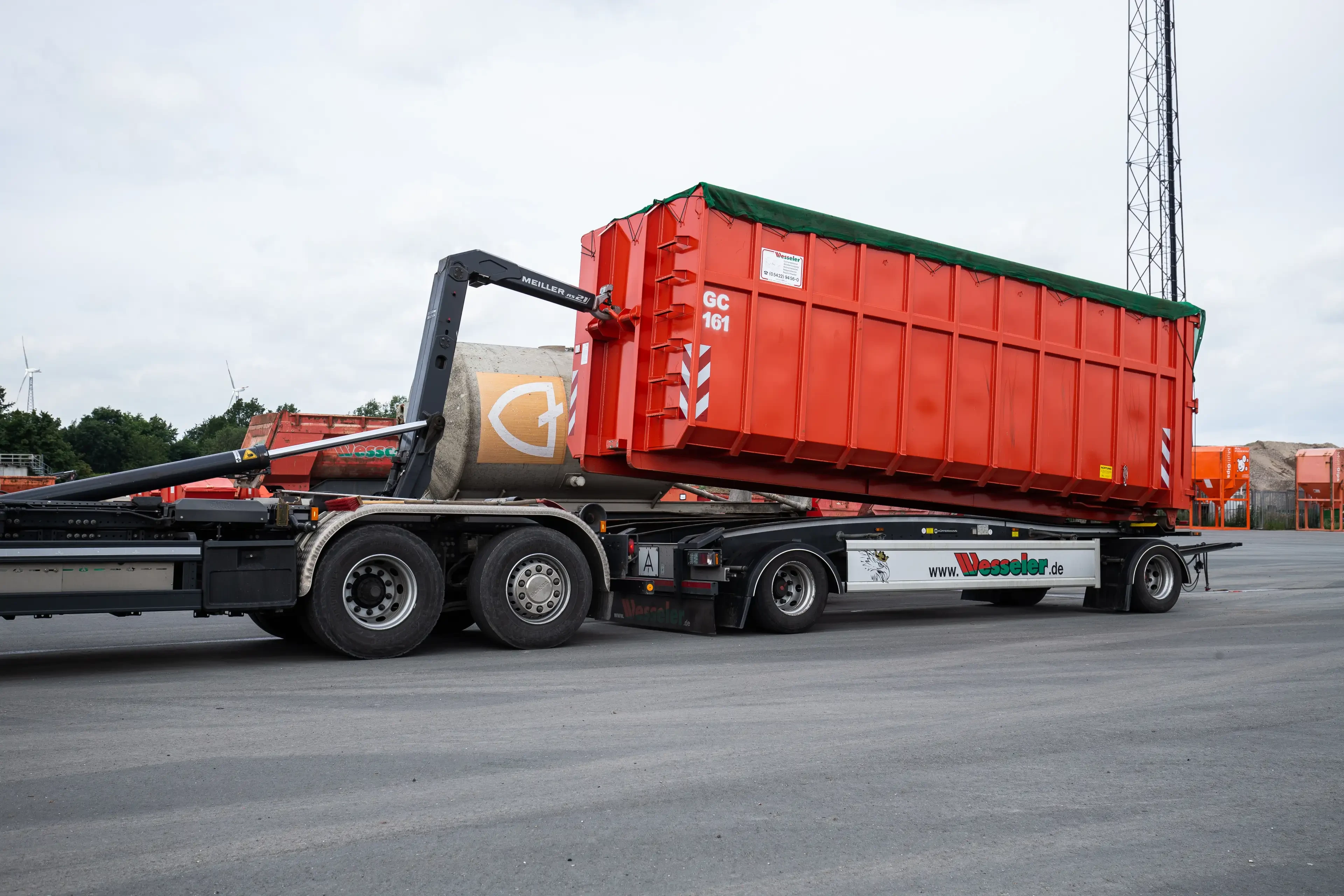 LKW mit Abrollcontainer von Wesseler auf einer Baustelle