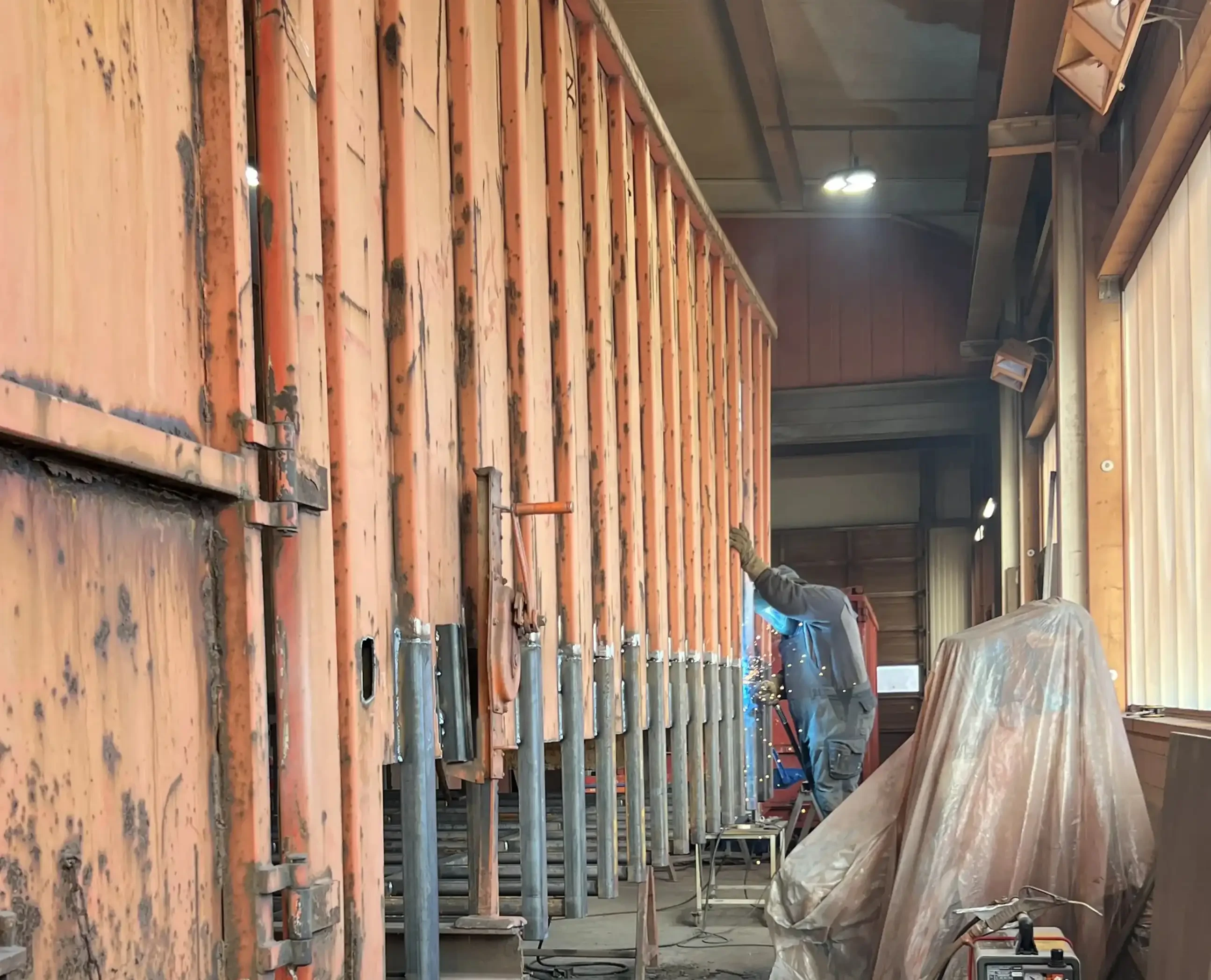 Schweißer arbeitet an einer großen Metallkonstruktion in einer Werkhalle – img-3951-beschnizzten-jpg.webp