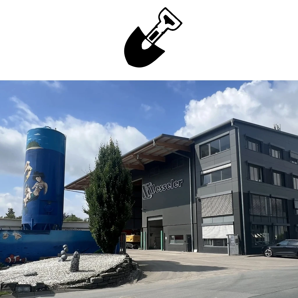 Moderne Firmengebäude mit Baustellenbetreuung und kreativ bemaltem Silo vor blauem Himmel