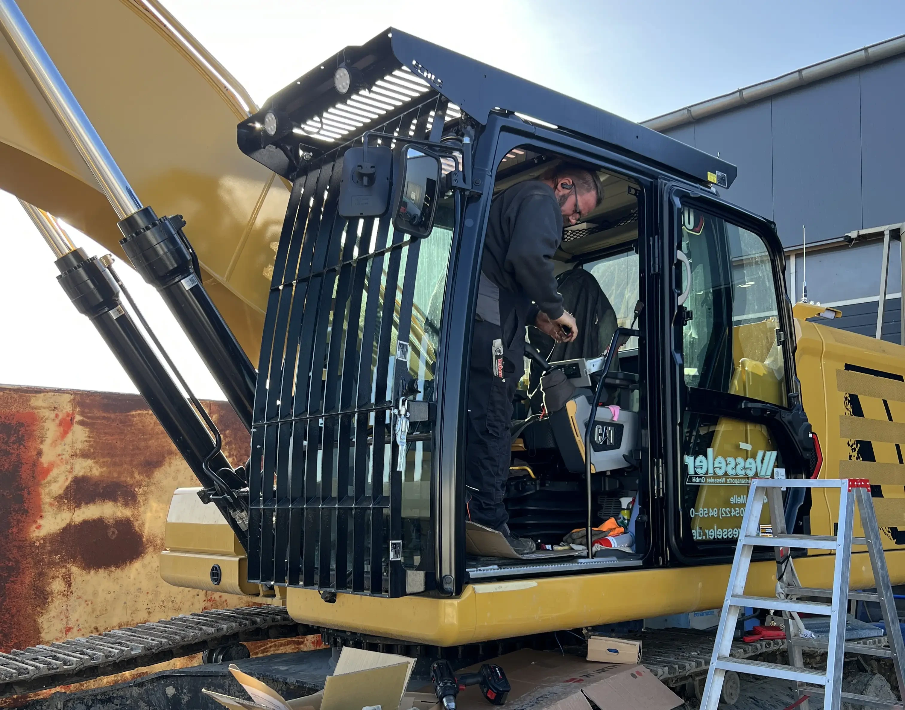 Arbeiter bei der Wartung eines CAT-Baggers auf einer Baustelle