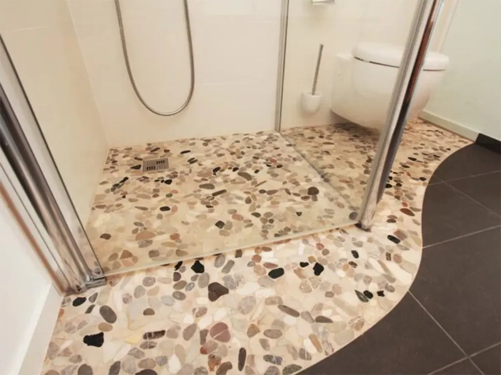 Boden aus Mosaikfliesen in einer modernen Dusche mit Steinoptik