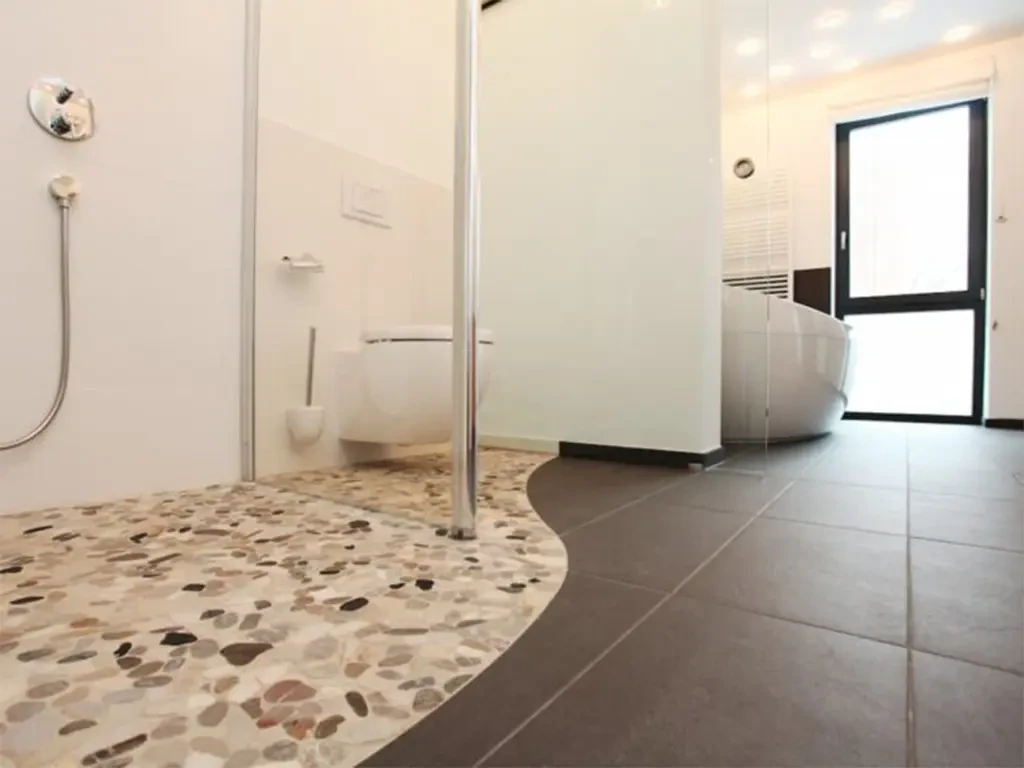 Modernes Badezimmer mit Mosaikboden und abgerundeter Fliesenübergang